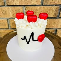White cake with red heart lollipops, white buttercream and heartbeat line decoration